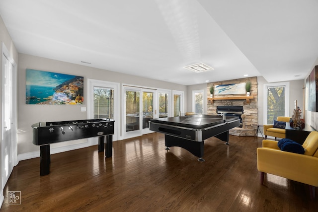 playroom with a stone fireplace, wood finished floors, and baseboards