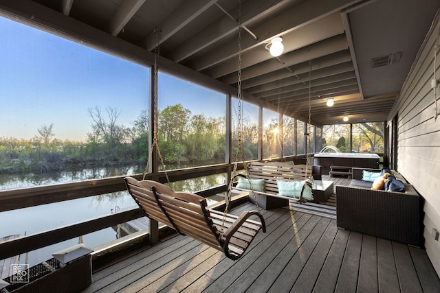 wooden terrace with a water view and outdoor lounge area