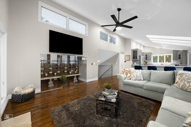 living area featuring ceiling fan, hardwood / wood-style flooring, high vaulted ceiling, baseboards, and recessed lighting
