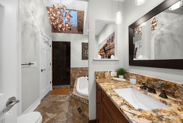 full bathroom with a tub with jets, vanity, a walk in shower, and a chandelier