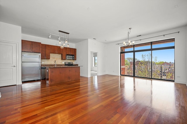 3300 W Irving Park Rd Unit F4, Chicago, IL 60618 - kitchen with stainless steel appliances, a chandelier, a center island, open floor plan, and dark wood-style flooring