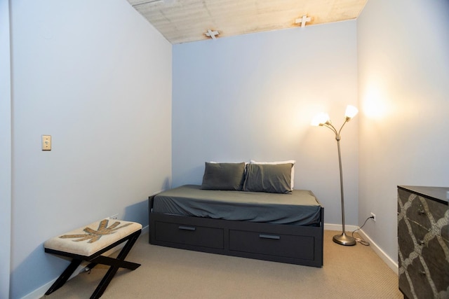 bedroom featuring light carpet and baseboards