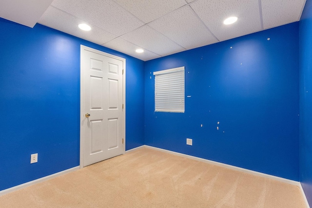 carpeted empty room with baseboards and a paneled ceiling