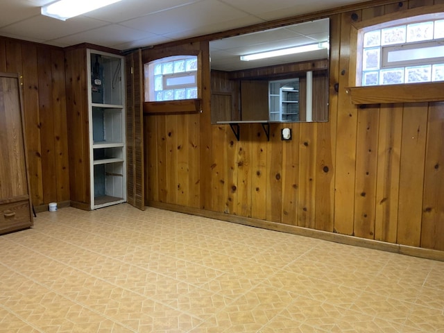 7835 W Berwyn Ave, Chicago, IL 60656 - unfurnished room featuring tile patterned floors, wood walls, and a drop ceiling