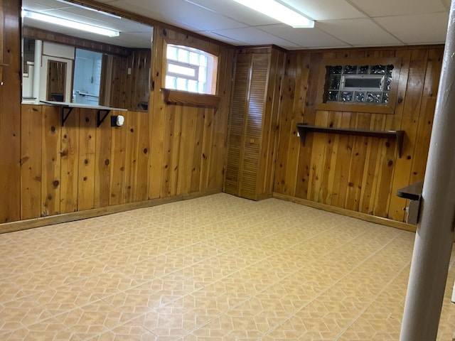 7835 W Berwyn Ave, Chicago, IL 60656 - basement featuring tile patterned floors, wood walls, baseboards, and a paneled ceiling