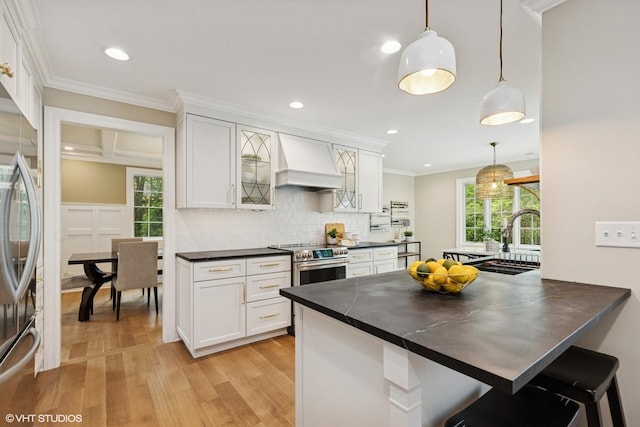 1414 N Ave, Bannockburn, IL 60015 - kitchen with custom range hood, appliances with stainless steel finishes, dark countertops, light wood-style flooring, and white cabinets