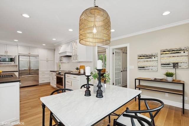1414 N Ave, Bannockburn, IL 60015 - kitchen featuring built in appliances, custom range hood, dark countertops, ornamental molding, and white cabinetry