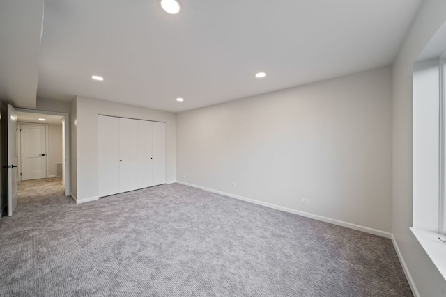 unfurnished bedroom featuring carpet floors, recessed lighting, baseboards, and a closet