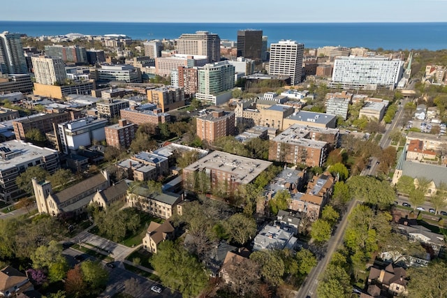 aerial view of property and surrounding area with nearby urban area and a large body of water