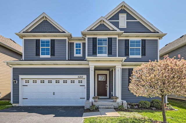 view of front of property with an attached garage and asphalt driveway