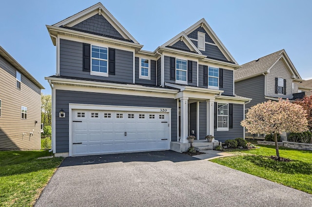 view of front facade featuring asphalt driveway, an attached garage, and a front lawn