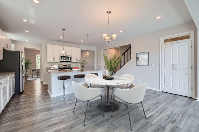 dining room with light wood-style floors, a chandelier, recessed lighting, baseboards, and stairway