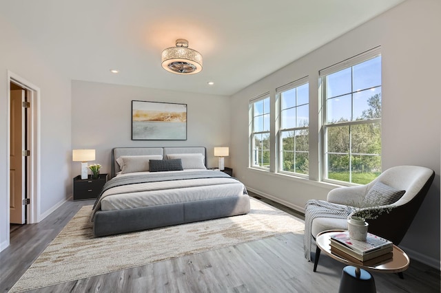 bedroom featuring baseboards, wood finished floors, and recessed lighting