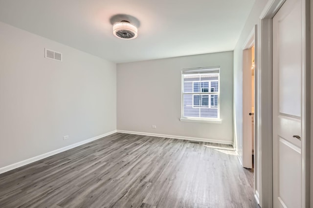 spare room with wood finished floors and baseboards