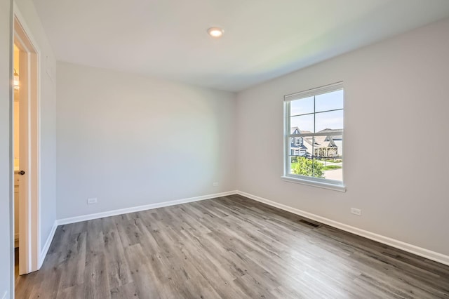 spare room with wood finished floors and baseboards