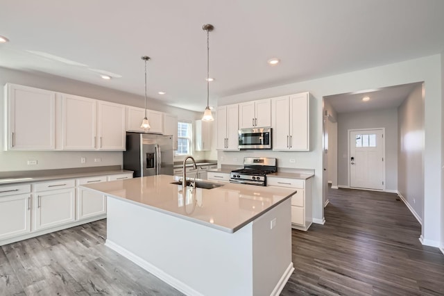 kitchen featuring appliances with stainless steel finishes, a sink, white cabinets, dark wood-type flooring, and recessed lighting