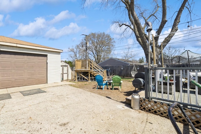 4 E Streamwood Blvd, Streamwood, IL 60107 - view of yard featuring an outdoor structure, a storage unit, a garage, driveway, and fence