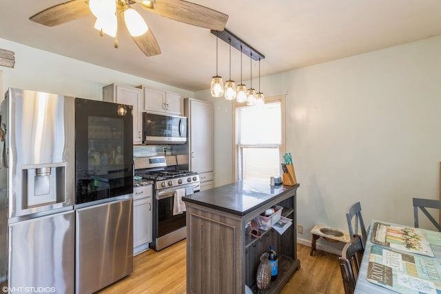 4 E Streamwood Blvd, Streamwood, IL 60107 - kitchen featuring stainless steel appliances, dark countertops, light wood-style flooring, a ceiling fan, and hanging light fixtures