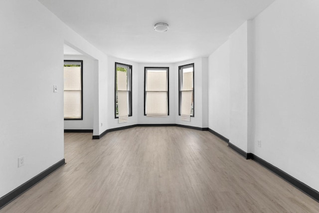 unfurnished room with wood finished floors and baseboards