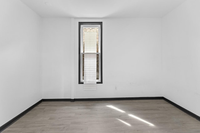 empty room with wood finished floors and baseboards