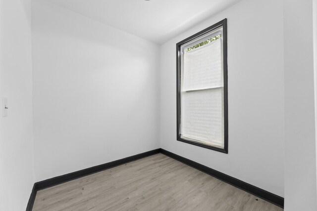 empty room featuring light wood-type flooring and baseboards