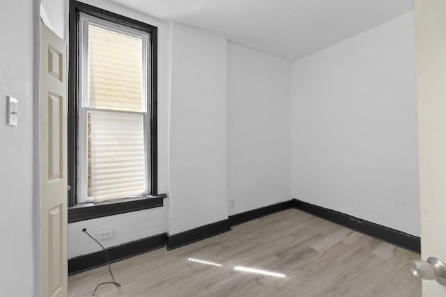 empty room featuring wood finished floors and baseboards
