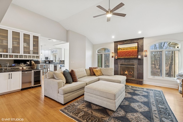 20662 Francisca Way, Frankfort, IL 60423 - living area featuring a tiled fireplace, vaulted ceiling, wine cooler, light wood finished floors, and ceiling fan
