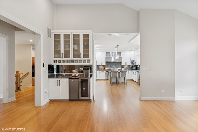 20662 Francisca Way, Frankfort, IL 60423 - bar area featuring light wood-style flooring, decorative backsplash, high vaulted ceiling, stainless steel dishwasher, and decorative light fixtures