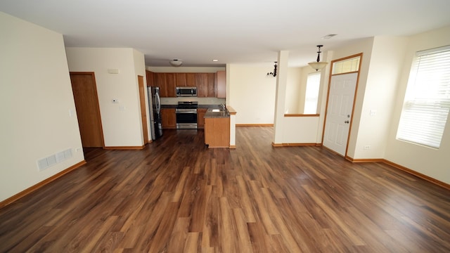 2620 Christie Dr, Algonquin, IL 60102 - kitchen with appliances with stainless steel finishes, open floor plan, dark countertops, baseboards, and dark wood-type flooring