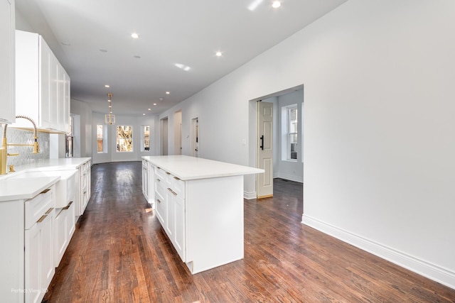 7317 S Maryland Ave, Chicago, IL 60619 - kitchen with a sink, recessed lighting, a kitchen island, white cabinetry, and dark wood-style flooring