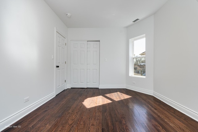 7317 S Maryland Ave, Chicago, IL 60619 - unfurnished bedroom with dark wood finished floors, baseboards, and a closet