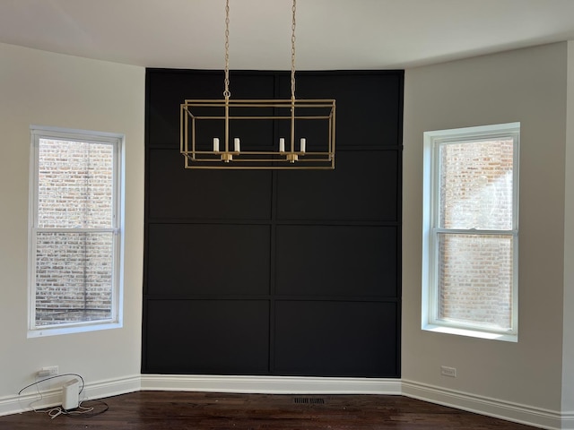 7317 S Maryland Ave, Chicago, IL 60619 - unfurnished dining area featuring baseboards, dark wood-style floors, and a chandelier
