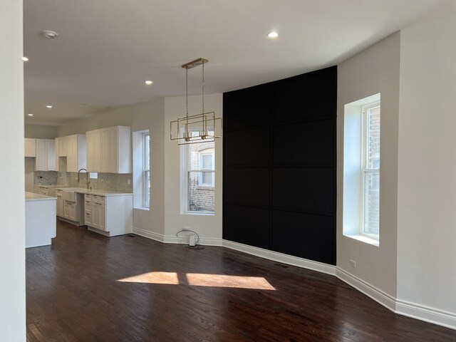 7317 S Maryland Ave, Chicago, IL 60619 - unfurnished dining area featuring dark wood-style flooring, baseboards, a chandelier, recessed lighting, and a sink