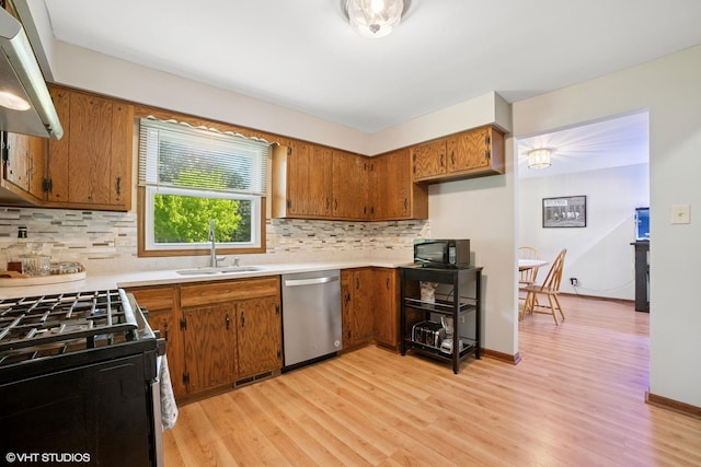 86 Brookside Dr, Elgin, IL 60123 - kitchen featuring stainless steel dishwasher, gas range oven, a sink, brown cabinets, and backsplash