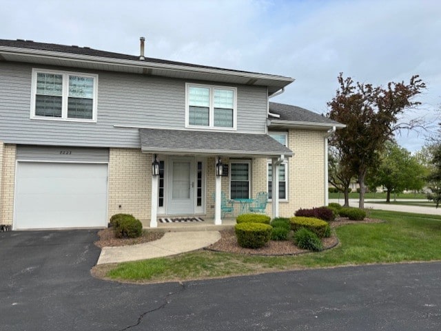 8223 170th St, Tinley Park, IL 60477 - view of front of house with a garage, a porch, driveway, and brick siding