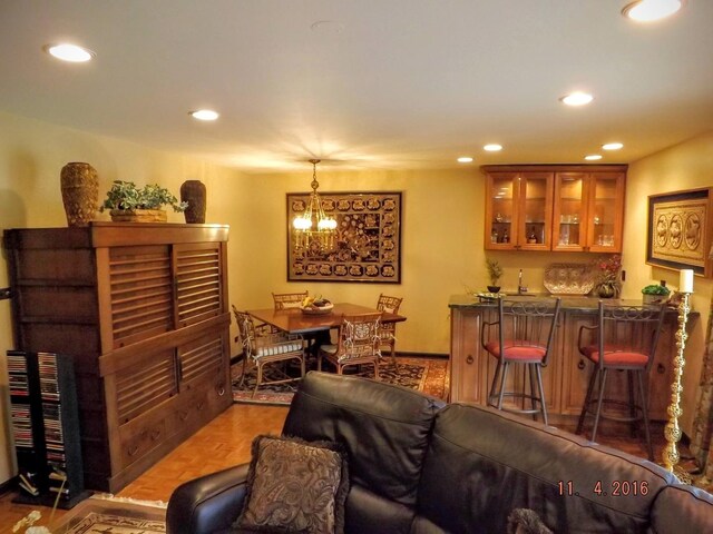living area with recessed lighting, a chandelier, and bar