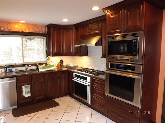 3550 Whirlaway Dr, Northbrook, IL 60062 - kitchen featuring stainless steel appliances, under cabinet range hood, a sink, dark countertops, and light tile patterned flooring
