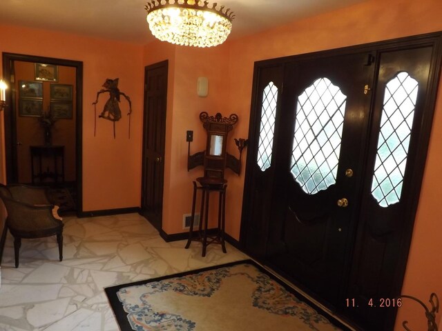 entrance foyer with a chandelier and baseboards
