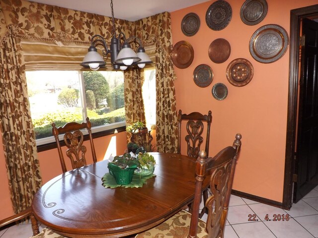 dining room featuring a chandelier, light tile patterned floors, and baseboards