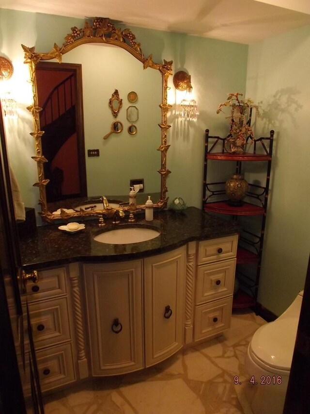 half bathroom featuring vanity and toilet
