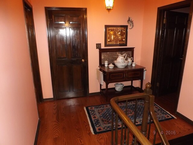 hallway with wood finished floors and baseboards