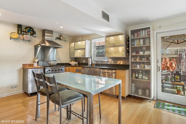 1747 N Fern Ct, Chicago, IL 60614 - kitchen with stainless steel dishwasher, wall chimney range hood, dark countertops, light wood-type flooring, and recessed lighting