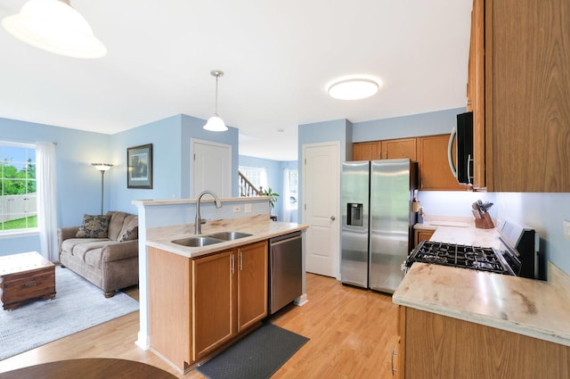 17 Ronan Ct, Lake In The Hills, IL 60156 - kitchen featuring appliances with stainless steel finishes, light wood-style flooring, a sink, light countertops, and brown cabinets