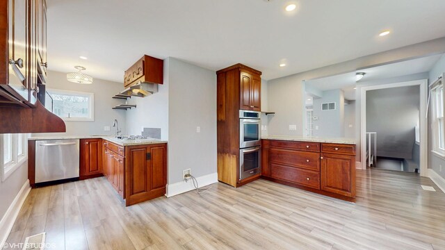 666 Greenview Ave, Des Plaines, IL 60016 - kitchen featuring appliances with stainless steel finishes, light wood-type flooring, baseboards, brown cabinetry, and a peninsula