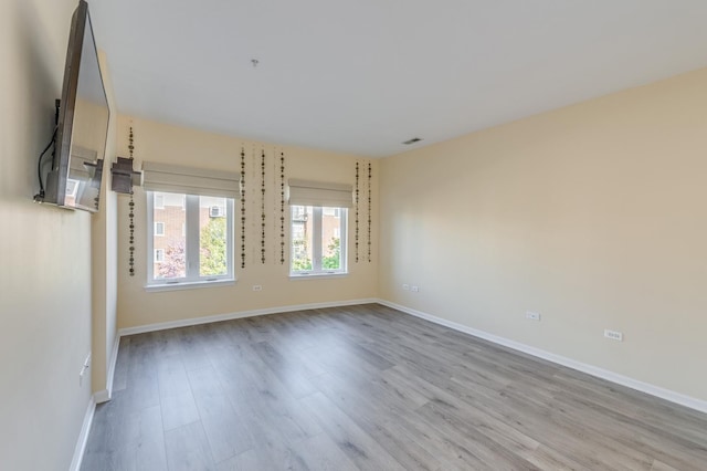 spare room featuring wood finished floors and baseboards