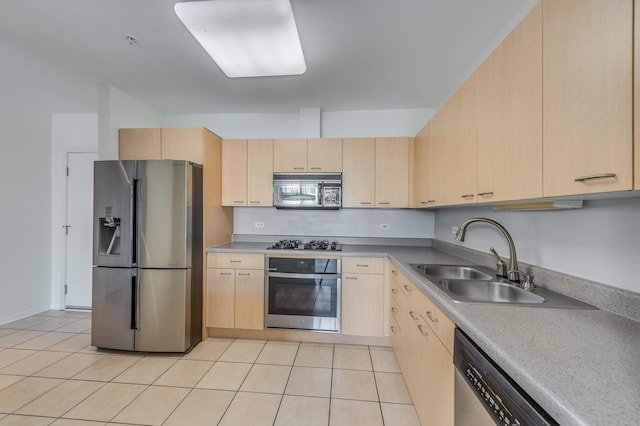 kitchen featuring appliances with stainless steel finishes, light brown cabinets, a sink, and light tile patterned floors
