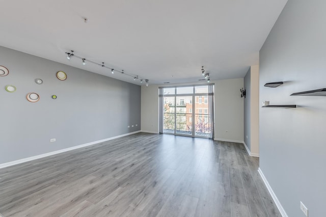 unfurnished living room with light wood-style flooring and baseboards