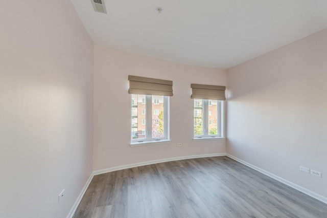 spare room with wood finished floors and baseboards