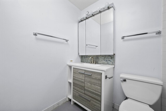 bathroom featuring decorative backsplash, toilet, vanity, and tile patterned floors