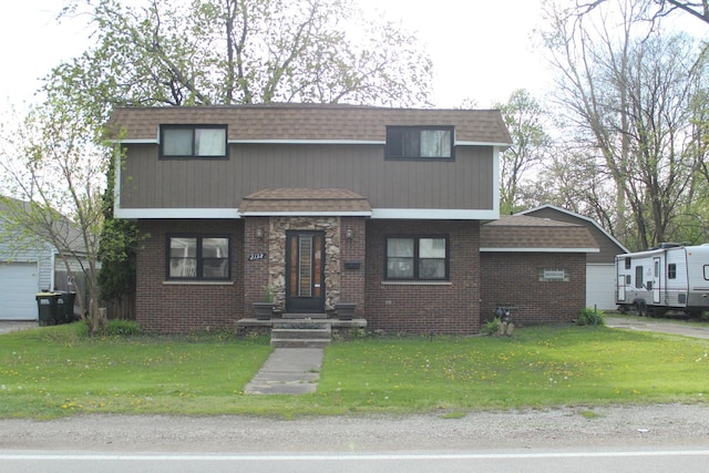 view of front of property featuring a front yard, roof with shingles, and brick siding